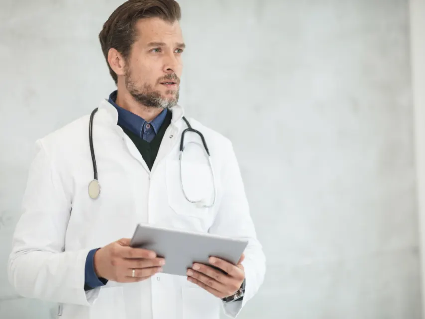 Farmacêutico de jaleco consultando um tablet